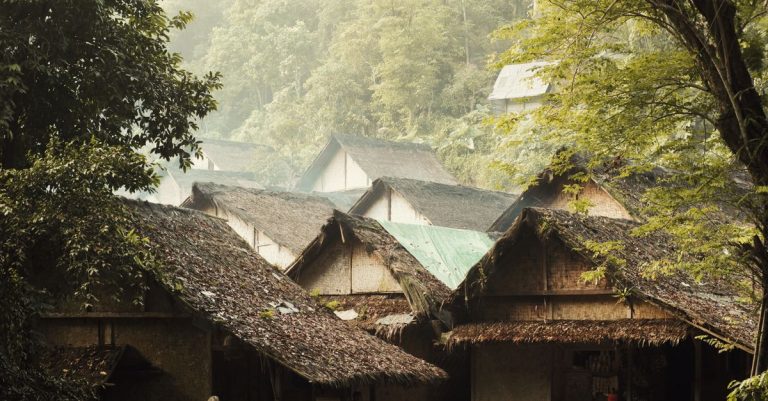 Rumah bambu rustik dikelilingi oleh pepohonan rimbun di Banten, Indonesia, menampilkan arsitektur tradisional.