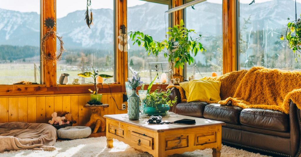 Interior ruang tamu yang hangat dan mengundang dengan pemandangan gunung yang menakjubkan melalui jendela besar.