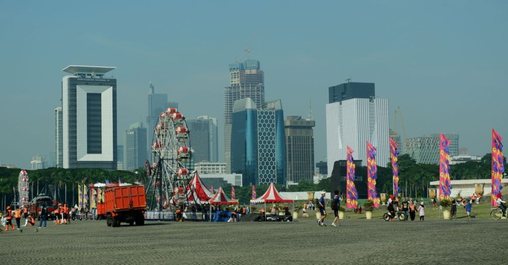 Karnaval kota dengan bianglala dan gedung pencakar langit di latar belakang, suasana perkotaan yang semarak.