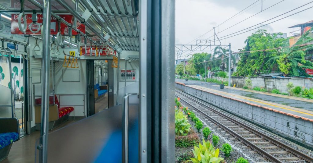 Pemandangan interior kereta api dan rel kereta Jakarta, menampilkan suasana transportasi modern dan perkotaan.
