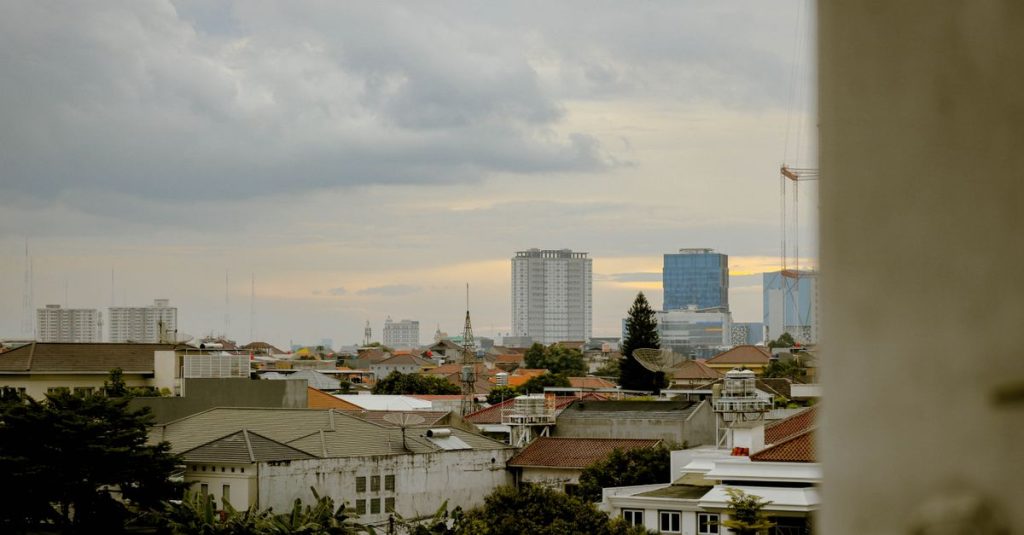 Pemandangan cakrawala Jakarta Barat yang menenangkan saat matahari terbenam, menyoroti arsitektur perkotaan.