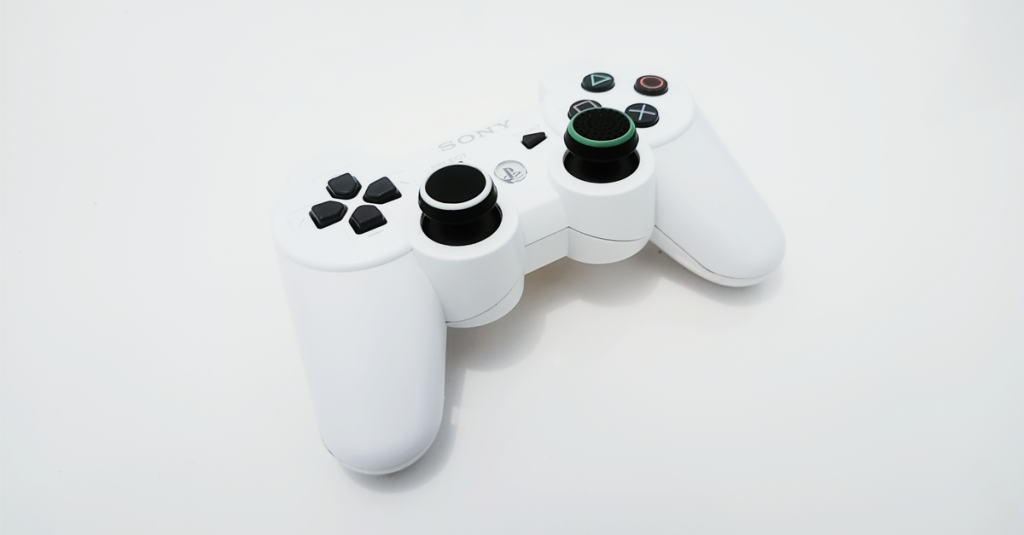 Tampilan dekat pengendali permainan berwarna putih, ideal untuk penggemar konsol PlayStation.