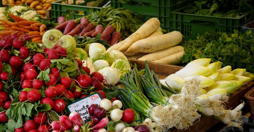 Kumpulan berwarna-warni dari sayuran segar di stan pasar petani, menampilkan produk dari peternakan ke meja.
