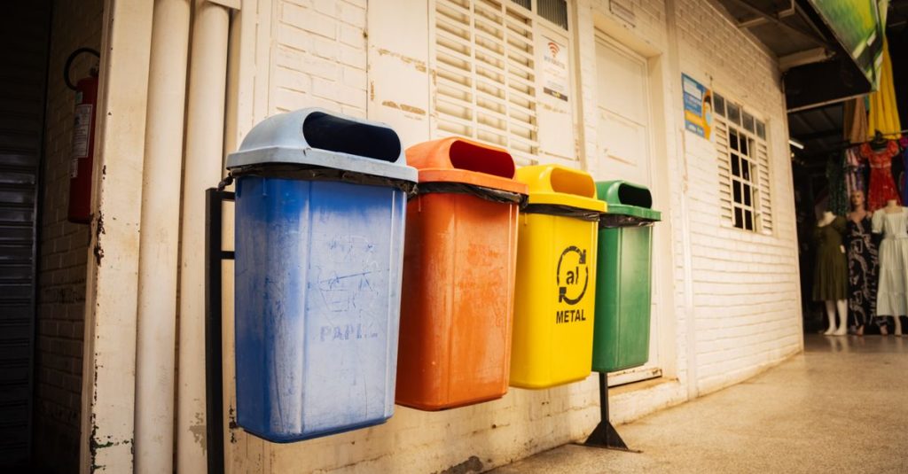 Empat tempat daur ulang untuk berbagai material di pengaturan pasar, menekankan pemilahan limbah dan kesadaran lingkungan.