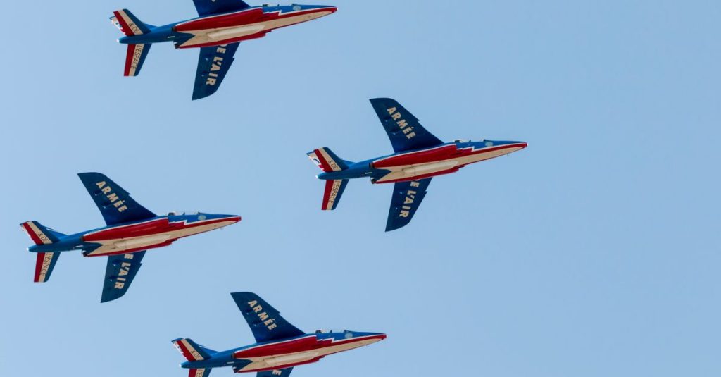 Jet tempur Patrouille de France Prancis melakukan penerbangan formasi dengan tiga warna cerah di langit biru Bukares.