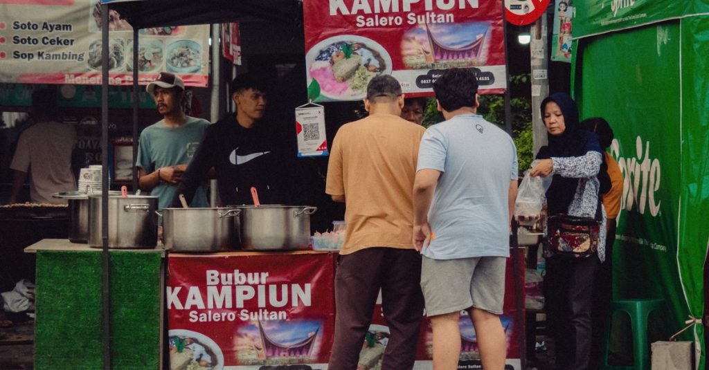 Suasana jajanan kaki lima yang meriah di sebuah pasar Jakarta dengan beragam masakan lokal.