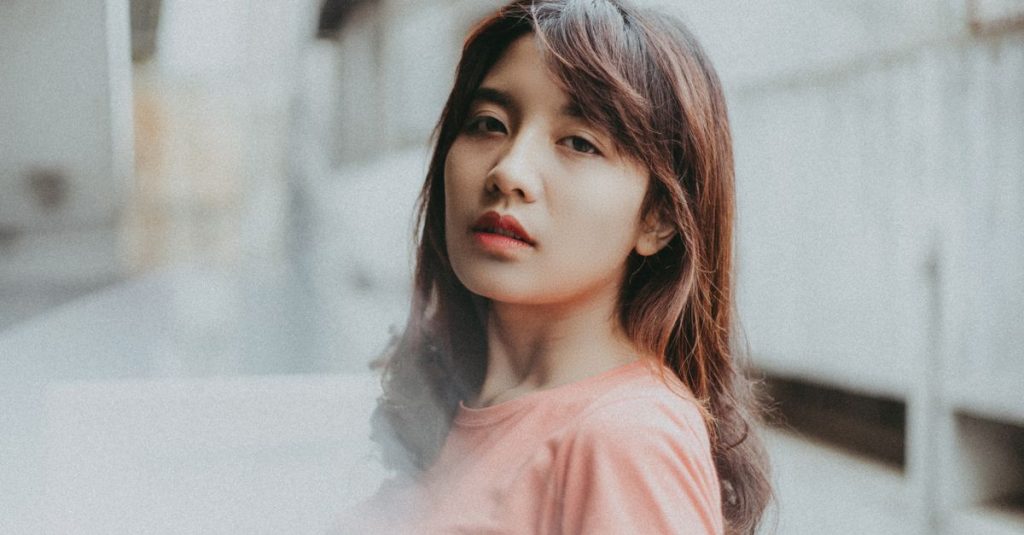Dekat pada seorang wanita muda dengan ekspresi percaya diri di lingkungan perkotaan.