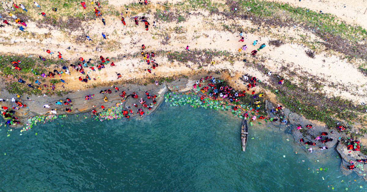 Gambar udara dari keramaian festival warna-warni di sepanjang tepi sungai di Rangamati, Bangladesh, yang menyoroti perayaan budaya.