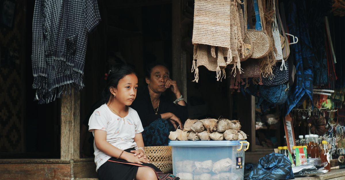 Pemandangan candid seorang wanita dan anak di pasar tradisional di Banten, Indonesia.