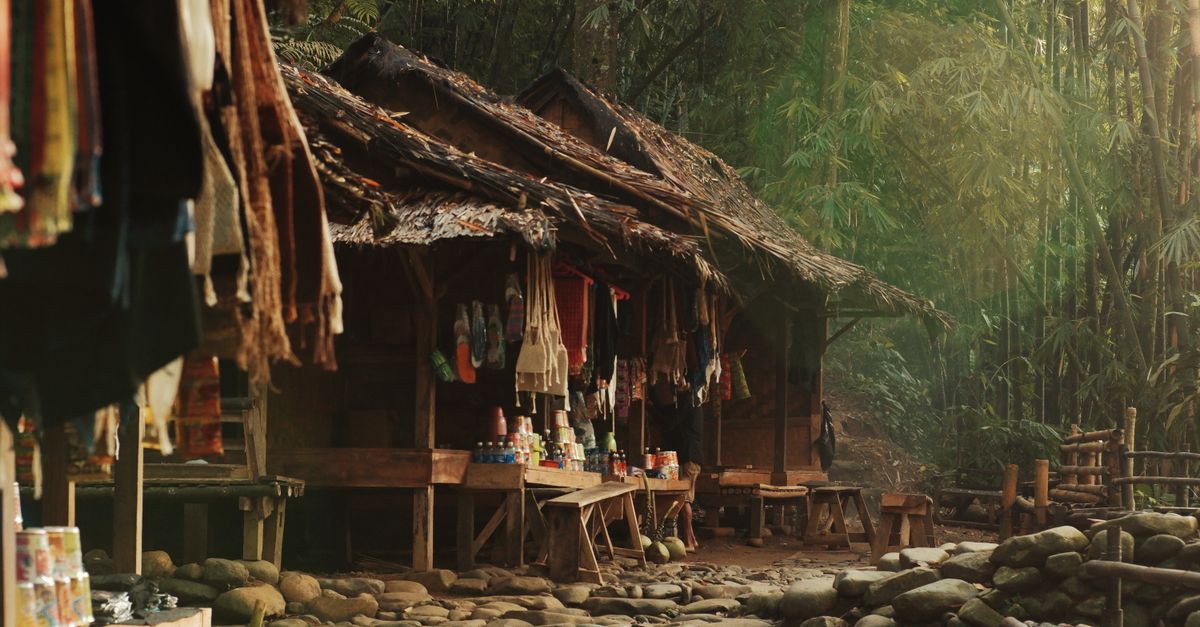 Kios-kios pasar sederhana di tengah hutan bambu, Banten, Indonesia, memamerkan kerajinan dan barang-barang lokal.