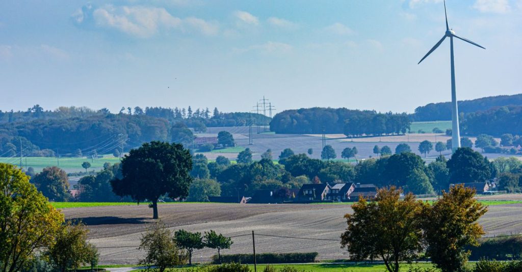 Pemandangan indah pedesaan Coesfeld, Jerman, dengan turbin angin di tengah ladang hijau.
