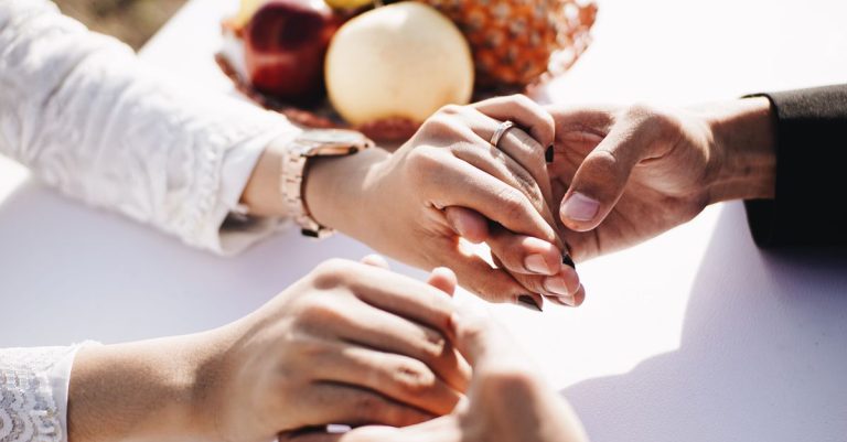Kedekatan sepasang kekasih yang bergandeng tangan di luar ruangan dengan buah-buahan di sebelahnya, menyampaikan cinta dan kasih sayang.