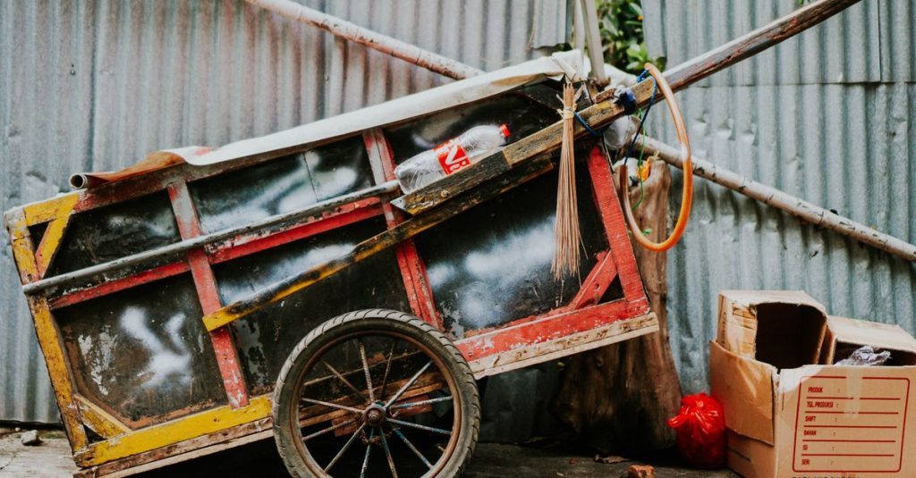 Sebuah kereta yang berwarna-warni dan kental dengan kesan rustik bersandar di dinding logam bergelombang di Jakarta.
