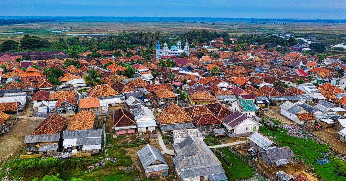 Pemandangan udara berwarna-warni dari desa pedesaan di Banten, Indonesia, menampilkan rumah tradisional dan hijauan subur.