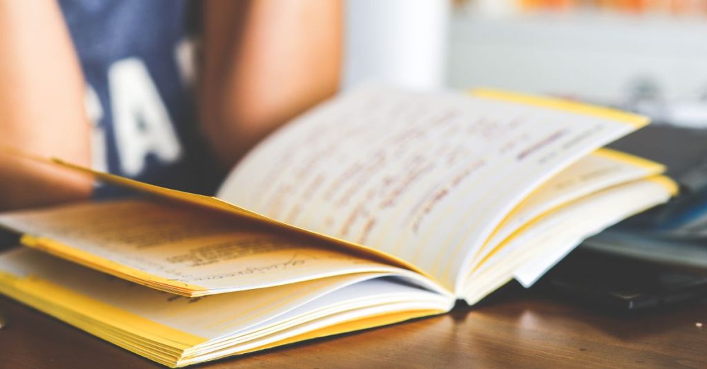 Sebuah buku catatan terbuka dengan catatan tangan, sempurna untuk belajar, pendidikan, atau menulis kreatif.