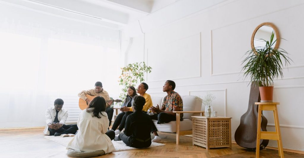 Sekelompok orang yang menikmati musik dan percakapan di suasana dalam ruangan yang nyaman.