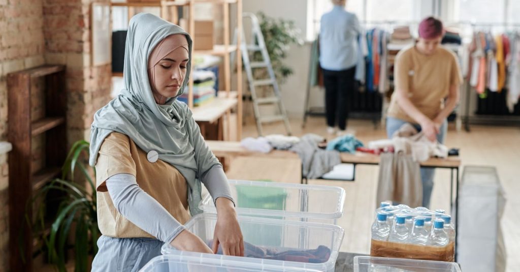 Relawan mengatur pakaian di pusat donasi, menunjukkan kerja sama dan layanan masyarakat.
