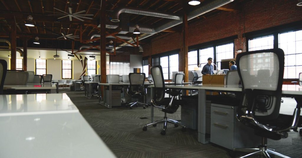 Ruang coworking industri terbuka dengan desain modern dan pencahayaan alami.