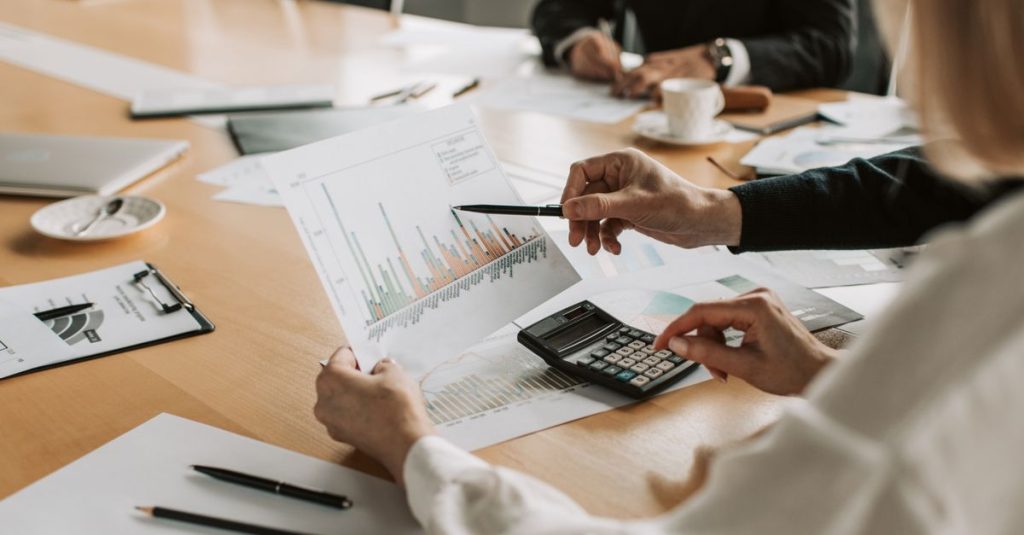Profesional meninjau grafik dan diagram keuangan selama pertemuan.