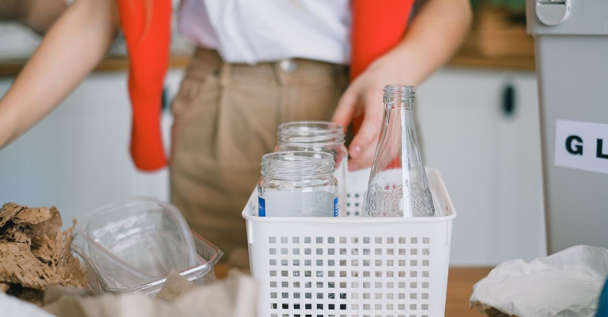 Wanita memilah botol kaca untuk didaur ulang di dapur modern.