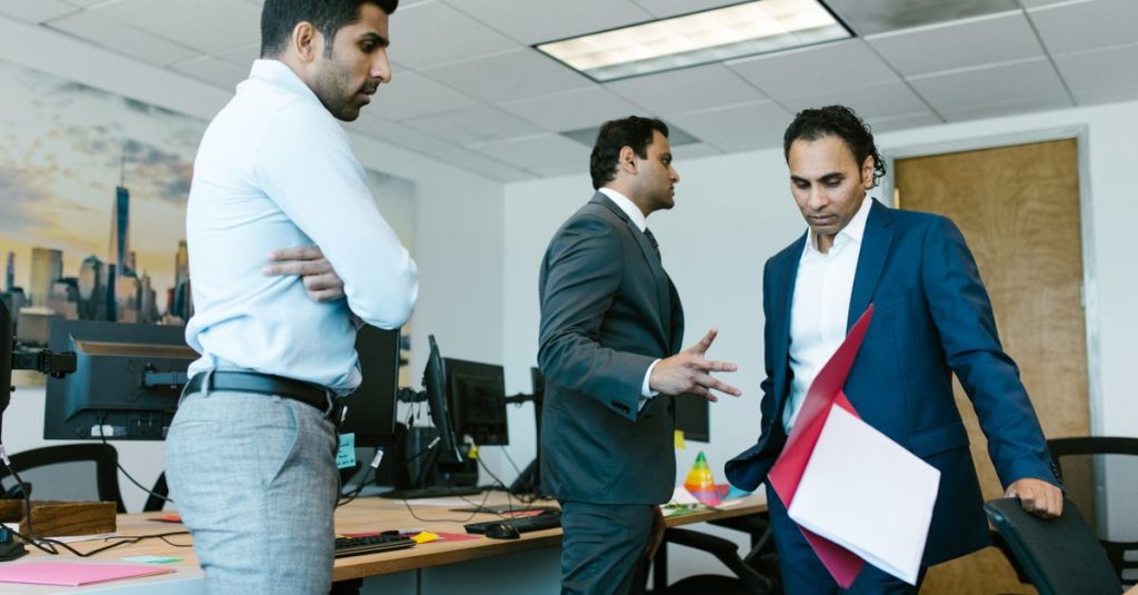 Momen tegang yang tertangkap di antara rekan-rekan selama rapat bisnis di lingkungan kantor modern.