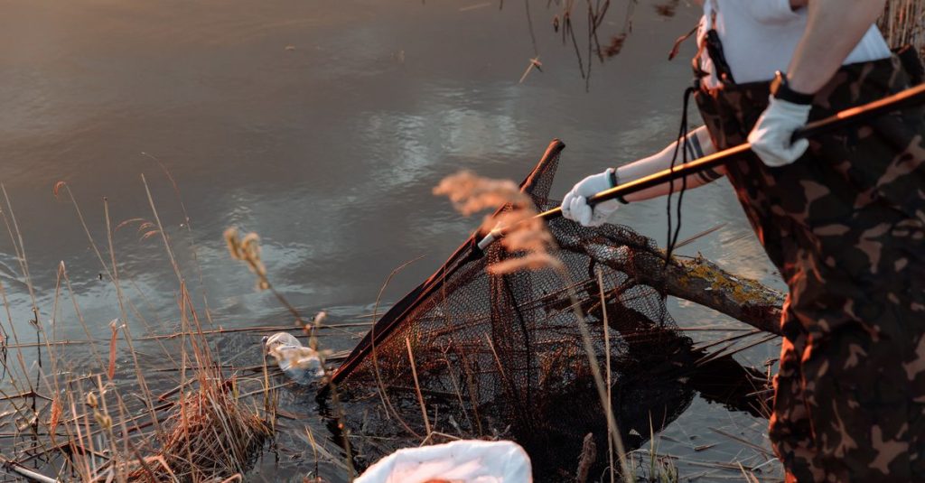 Orang membersihkan danau dengan jaring, mempromosikan kesadaran lingkungan dan konservasi.