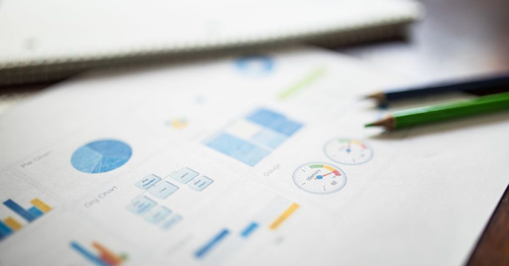 Ilustrasi laporan keuangan bisnis yang menampilkan berbagai grafik dan diagram di atas kertas.