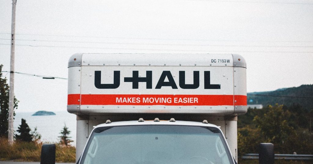 Truk U-Haul yang diparkir di pinggir jalan dengan latar belakang luar ruangan yang indah.