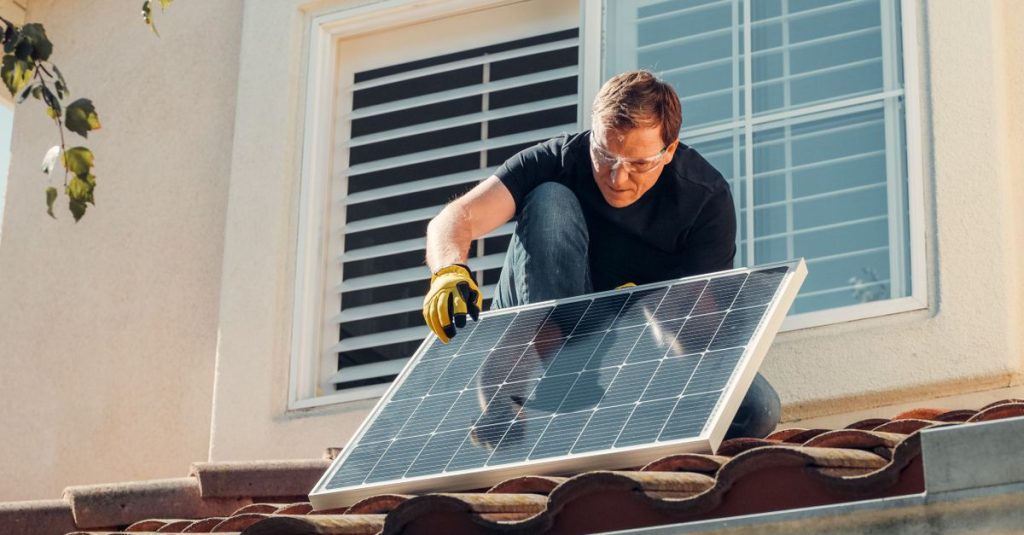 Teknisi solar memasang panel fotovoltaik di atap, mempromosikan energi terbarukan.